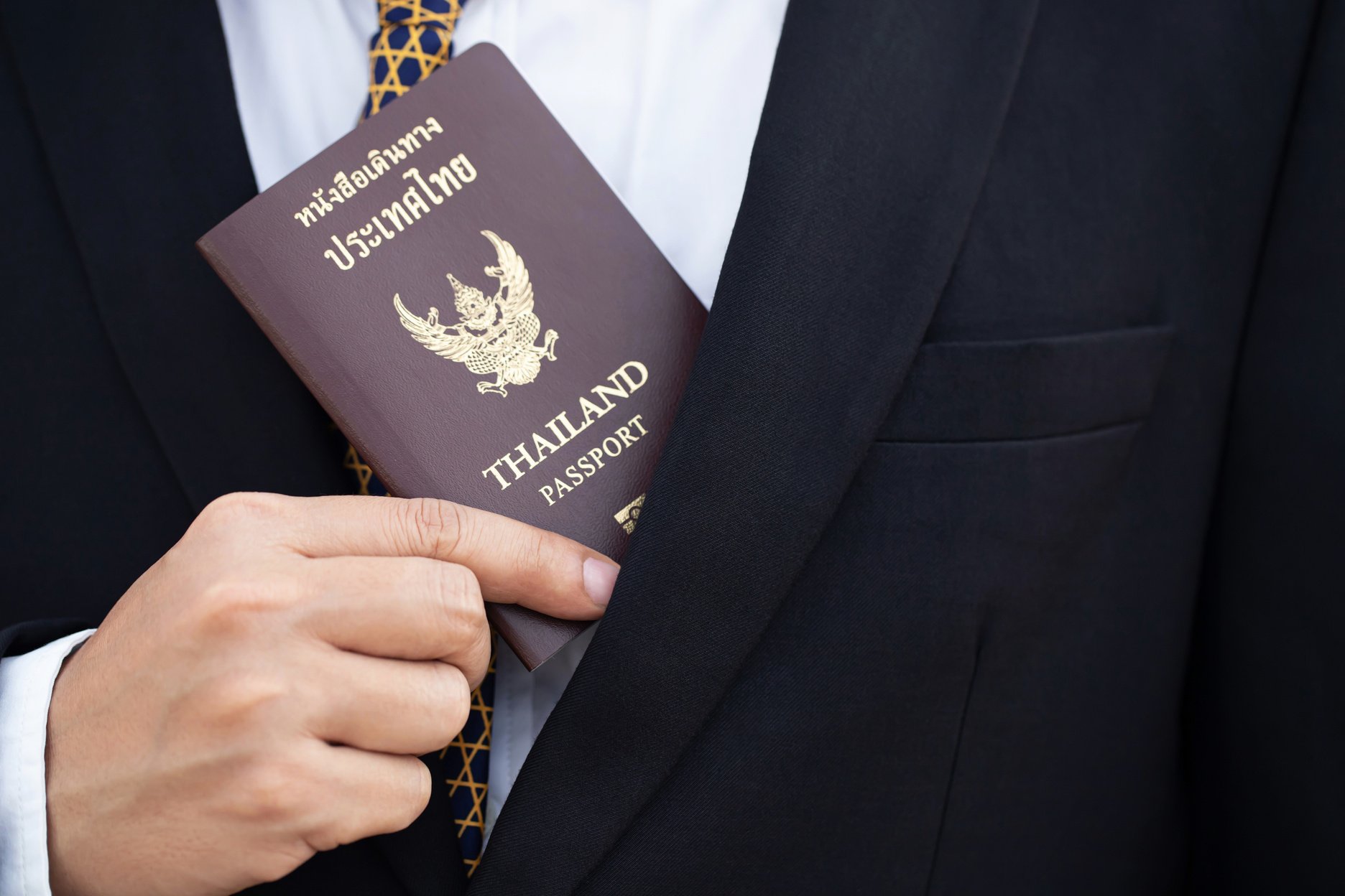 Man Inserting Thailand Passport in His Suit
